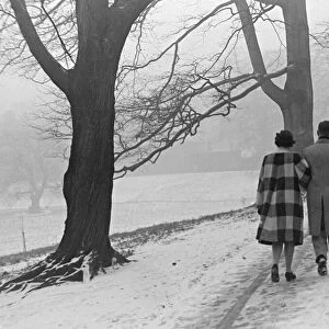 A couple walking in a snowy Regents Park, London. 21st January 1942