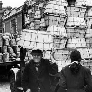 Covent Garden Market, Elderly man carried baskets on his head through the market streets Covent Garden Market, Elderly man carried baskets on his head through the market streets