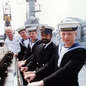 Fünf Besatzungsmitglieder der HMS Jupiter blicken auf die Entfernung zu ihrem Heimatstützpunkt und warten darauf Fünf Besatzungsmitglieder der HMS Jupiter blicken auf die Entfernung zu ihrem Heimatstützpunkt und warten darauf