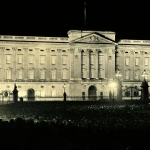 Crowds gather outside the gates of Buckingham Palace following the coronation of George