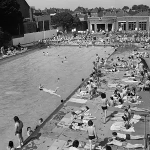 Crowds of sunbathers at the Twickenham outdoor swimming pool, London. 7th June 1975
