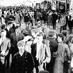 Curious crowds pass the sideshows at the Hoppings in 1965 at Newcastle Town Moor