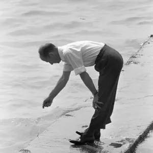 Dad is left holding the line, whilst trying to keep his feet dry during a day trip Dad is left holding the line, whilst trying to keep his feet dry during a day trip