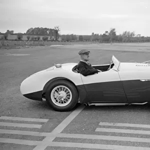 Daily Herald motor racing correspondent Thomas H Wisdom sitting at the wheel of an