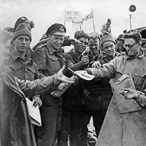 Daily Mirror war correspondent handing out copies to the troops on the Normandy invasion