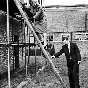 Dame Edith Pitt, Conservative MP climbs a ladder assisted by Mr Dennis Howell PM when