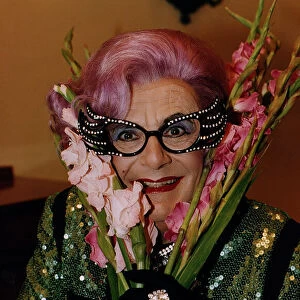 Dame Edna Everage Barry Humphries gladioli gladioluses purple hair large glasses black