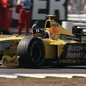 Damon Hill bei der britischen Großpreis-Veranstaltung im Juli 1999 winkt den Zuschauern zu Ende des Rennens an. Damon Hill bei der britischen Großpreis-Veranstaltung im Juli 1999 winkt den Zuschauern zu Ende des Rennens an.
