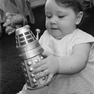 The daughter of Raymond Cusick designer of the Daleks from Doctor Who playing with a toy