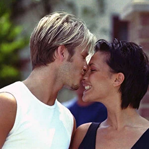 David Beckham and Victoria Adams, pictured in a romantic kiss outside their home