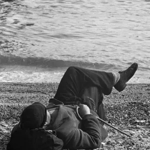 A day-tripper from Londons East End, relaxes in the summer sunshine on the beach A day-tripper from Londons East End, relaxes in the summer sunshine on the beach