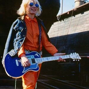 Debbie Harry January 1980 Holding guitar sun glasses orange suit blue denim jacket