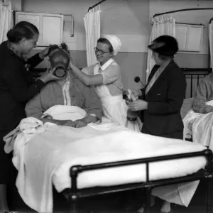 Demonstrating a gas mask on a patient in hospital in the early years of the Second World Demonstrating a gas mask on a patient in hospital in the early years of the Second World