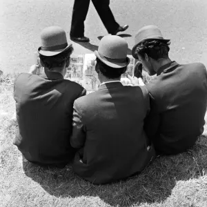 Derby Day at Epsom. Pictured, three lads from Newmarket sitting on the grass studying Derby Day at Epsom. Pictured, three lads from Newmarket sitting on the grass studying