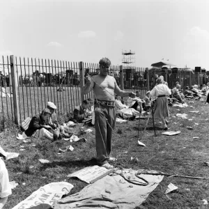 Derby Day at Epsom. Pictured, a strong man prepares to wrap himself in chains Derby Day at Epsom. Pictured, a strong man prepares to wrap himself in chains
