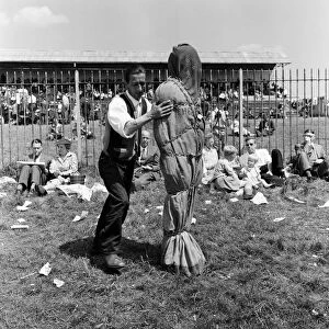 Derby Day at Epsom. Pictured, a strong man wrapped in chains. 3rd June 1959