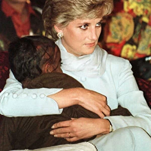 Diana, Princess of Wales cuddles a blind child during a visit to the Shaukat Khanum