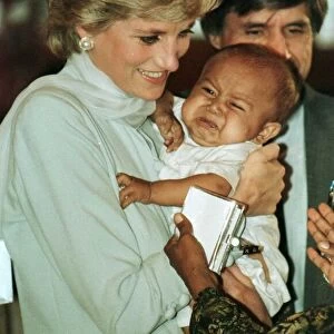 Diana, Princess of Wales holding a baby during prize giving ceremonies on a visit to