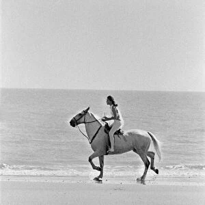 Diana Rigg, who plays Emma Peel, pictured riding a white horse across the beach at St