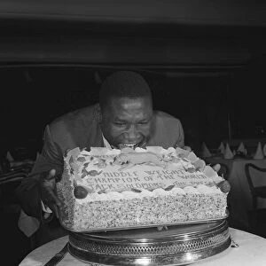 Dick Tiger Middleweight Boxing Champion eating his cake at a West End luncheon