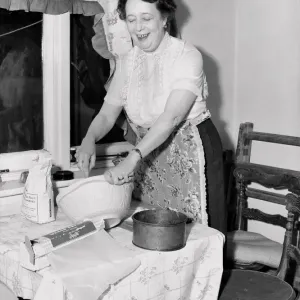 Domestic scenes: A woman making cakes in her kitchen at home. 1954 Domestic scenes: A woman making cakes in her kitchen at home. 1954