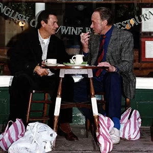 Don Henderson Actor & Michael Elphick actor sitting at pavement cafe table with shopping