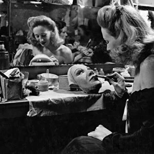In the dressing rooms of the London Palladium we see Carol Trent making up her mask which