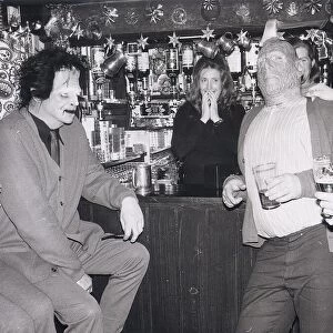 Drinkers standing at the bar of the Red Lion in Kings Langley Hertfordshire wearing masks