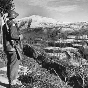 Driver C. A. Langford looks over snow covered territory of an American held sector Driver C. A. Langford looks over snow covered territory of an American held sector