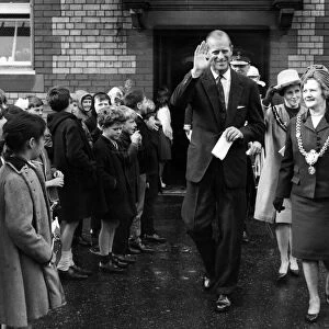 The Duke of Edinburgh walks through the lines of flag waving pupils at Kitchener Road