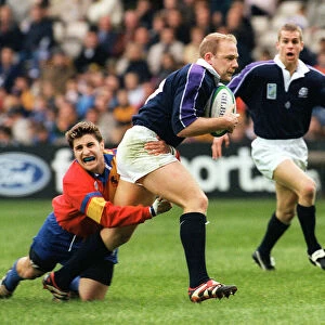 Duncan Hodge holds ball for Scotland October 1999 as he is tackled by Andrei Kovalenco of