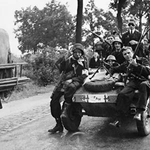 Dutch forces of the interior called P. A. N. crowd on to a captured German car in Eindhoven