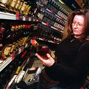 Duty free shop at Edinburgh airport February 1999 Woman looking at bottle of spirits
