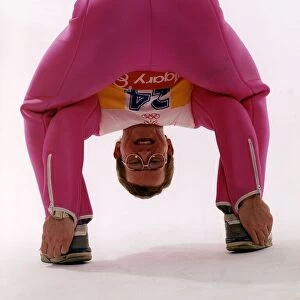 Eddie Edwards in pink ski clothing bending down and touching his heels