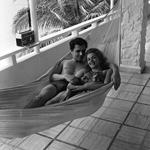 Edmond Purdom actor and Linda Christian actress on holiday laying in a hammock
