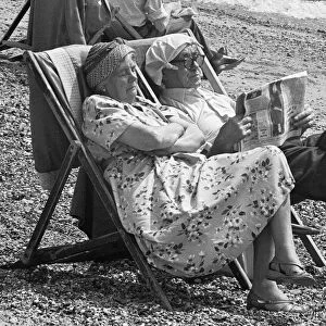 Elderly day-trippers from Londons East End, relax in the summer sunshine