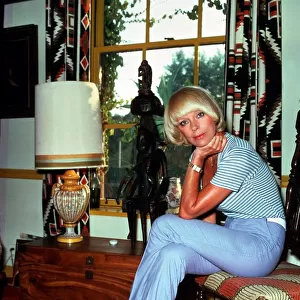Elke Sommer, actress inside a house sitting on a chair sex icon