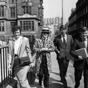 Elton John arrive à la cour. Elton demande une part plus importante des 20 millions qu'il