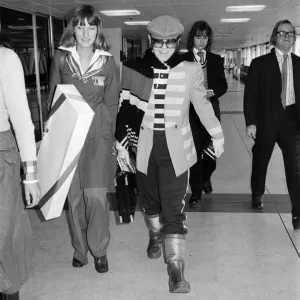 Elton John leaving Heathrow airport for a flight to Los Angeles. 9th January 1977