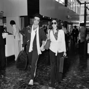 Elton John leaving Heathrow airport hand in hand with Connie Papras