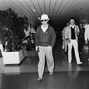 Elton John leaving Heathrow Airport for Paris to make a TV appearance. 29th June 1983