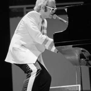 Elton John se produisant sur scène, lors des tournées de concerts d'Elton John et Ray Cooper.