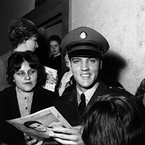 Elvis Presley signs autographs at press conference March 1960 for fans in Germany