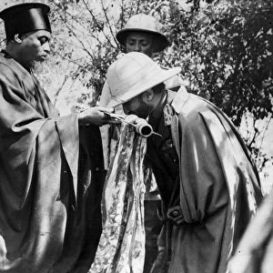 Emperor Haile Selassie kissing the cross offered by the High Priest of Debra Marcos after