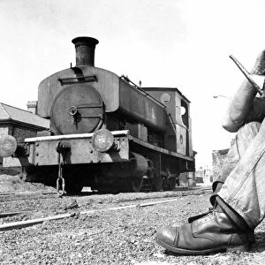 An engineer taking a break from working on this old steam locomotive on 21st August 1972