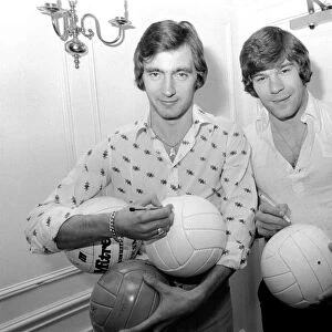 England team at hotel: Alan Hudson left and Malcolm MacDonald sign match footballs