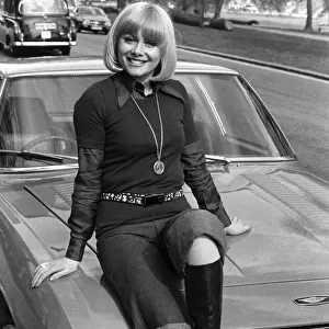 Entertainment actress Anne Aston sitting on the bonnet of her car. May 1976 P017209