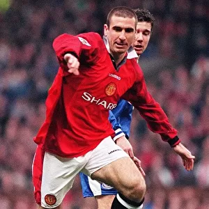 Eric Cantona fends off a Leicester defender during their match at Old Trafford