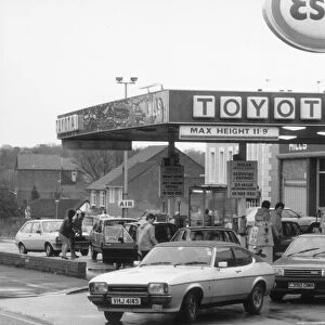 Esso Petrol Station with cars filling up and Ford Capri leaving. 2nd March 1986
