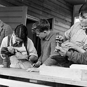 Evacuee children repairing shoes. 7th May 1940